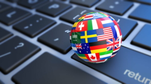 International business concept with a computer keyboard and world flags on a globe 3D illustration.